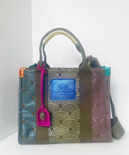 Load image into Gallery viewer, Handbag with geometric pattern and visible brand logo on a white background