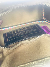 Load image into Gallery viewer, Close-up of a beige fabric product with a label and colorful trim.