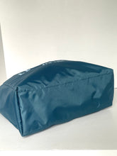 Load image into Gallery viewer, A dark teal blue waterproof bag or cover with white lettering on top, photographed on a plain light gray background.