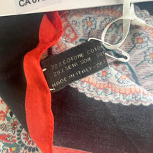 Load image into Gallery viewer, Textile with red fabric and a label on a stand