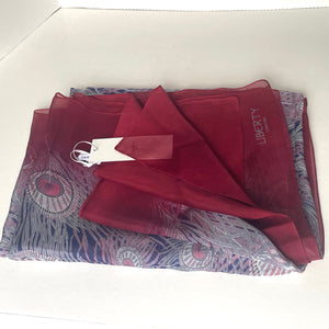 Red scarf with peacock feather pattern on a white background