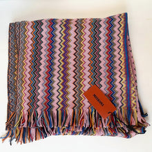 Load image into Gallery viewer, Colorful zigzag patterned blanket with a brand tag on a white background