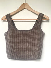 Load image into Gallery viewer, Houndstooth patterned crop top on a wooden hanger against a white background