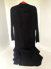 Load image into Gallery viewer, A black ribbed knit long-sleeve turtleneck dress displayed on a red hanger against a white corner wall.