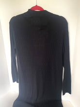 Load image into Gallery viewer, A black ribbed long-sleeve mock neck sweater hanging on a red hanger against a white wall.