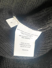 Load image into Gallery viewer, Close-up of a dark charcoal gray ribbed knit garment showing a white sewn-in size and material label.