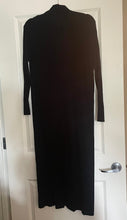 Load image into Gallery viewer, A black long-sleeve mock-neck knit dress hanging on a hanger against a white interior door.