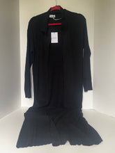 Load image into Gallery viewer, A black long-sleeve cardigan dress with a matching black skirt, hanging on a red hanger against a plain white corner wall. The cardigan features a collar and front button closure, and the dress has a flared skirt hem.