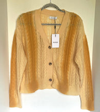 Load image into Gallery viewer, Beige cardigan on a hanger with a visible brand tag against a white background