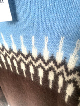 Load image into Gallery viewer, Close-up of a knitted fabric with a pattern on a blue background