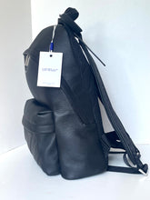 Load image into Gallery viewer, Black leather backpack with a visible brand tag on a white background