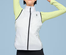 Load image into Gallery viewer, Person wearing a white running jacket with a green long-sleeve shirt underneath on a light blue background