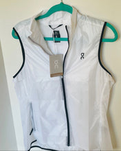 Load image into Gallery viewer, White running vest with black accents on a hanger against a white background