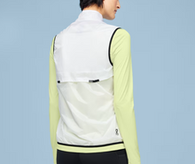 Load image into Gallery viewer, Person wearing a light green and white jacket on a blue background