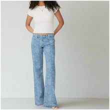 Load image into Gallery viewer, Person wearing light blue acid-wash jeans and a white crop top on a plain background