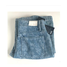 Load image into Gallery viewer, Folded blue jeans with a brand tag on a white background