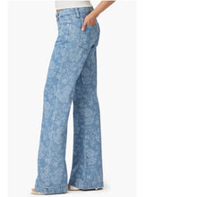 Load image into Gallery viewer, Light blue acid-wash jeans worn by a person on a white background