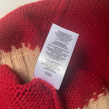 Load image into Gallery viewer, Close-up of a red and beige knitted garment with a label on a white background
