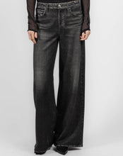 Load image into Gallery viewer, A person wearing wide-leg black washed denim jeans with a sheer black long-sleeve top, shown from the waist down against a light gray studio background.