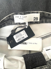 Load image into Gallery viewer, Close-up of a Rag &amp; Bone garment neck label area showing a size 28 tag, retail price tag, and brand tag on a gray and white textured fabric.