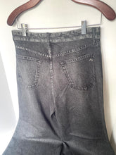 Load image into Gallery viewer, Back view of dark gray acid-washed denim jeans hanging on a wooden hanger against a plain off-white wall.