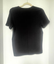 Load image into Gallery viewer, Black t-shirt on a hanger against a white background