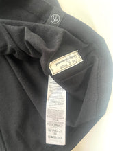 Load image into Gallery viewer, Close-up of a black garment with a brand label and tag.