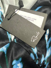 Load image into Gallery viewer, Close-up of a garment tag attached to a black satin fabric with blue and green abstract print. The tag is dark gray with a white script logo reading 'Ranieri' and a white size/lot label above it.
