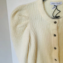 Load image into Gallery viewer, Cream-colored cardigan with buttons on a hanger against a white background