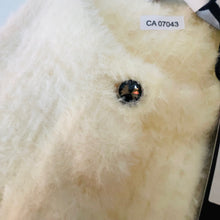 Load image into Gallery viewer, Close-up of a white animal with a black object on its back, labeled 'CA 07043'.