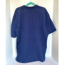 Load image into Gallery viewer, Blue shirt on a hanger against a white wall