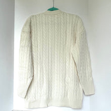 Load image into Gallery viewer, Cream-colored cable knit sweater on a white background