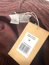 Load image into Gallery viewer, Close-up of a ribbed knit sweater tag and size label. The knit fabric is a dark mahogany brown, and the tags show the brand Royal Robbins and size M.