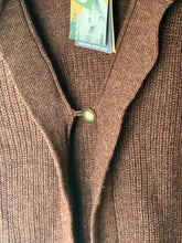 Load image into Gallery viewer, Close-up of a brown ribbed knit cardigan sweater with a single button closure and a visible hangtag near the collar.