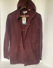 Load image into Gallery viewer, A ribbed knit hooded cardigan sweater in a deep burgundy or maroon color, hanging on a wooden hanger against a white background. The cardigan features a hood, a single button closure, and side pockets, with a visible brand tag that reads 'BETTER LIVES'.