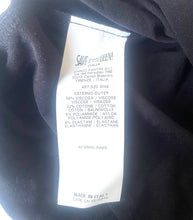 Load image into Gallery viewer, A close-up of a black garment's inner neck area showing a white care label with Italian text and the brand name SAVE THE QUEEN.