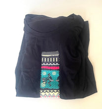 Load image into Gallery viewer, A folded black long-sleeve top or dress with a colorful geometric and tribal-style embroidered panel on the front, displayed on a plain white background.