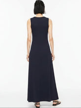 Load image into Gallery viewer, A woman viewed from behind wearing a sleeveless black and white horizontally striped maxi dress, paired with black sandals, against a plain white studio background.