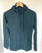 Load image into Gallery viewer, A dark teal heathered pullover hoodie with a drawstring hood and kangaroo pocket, hanging on a wooden hanger against a plain white wall.
