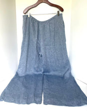 Load image into Gallery viewer, Blue denim wide-leg pants on a hanger against a white background