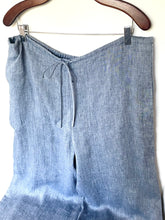 Load image into Gallery viewer, Blue linen pants on a hanger against a white background