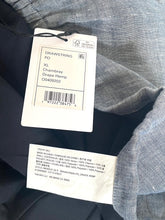 Load image into Gallery viewer, Clothing tag on a piece of fabric with text and numbers.