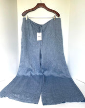 Load image into Gallery viewer, Blue wide-leg pants on a hanger with a white background