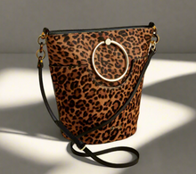 Load image into Gallery viewer, Leopard print handbag with a circular handle on a beige background