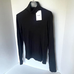 Black turtleneck sweater on a hanger with a visible brand tag against a white background