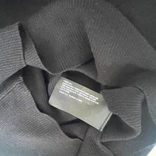 Load image into Gallery viewer, Gray sweater with a label on a dark background