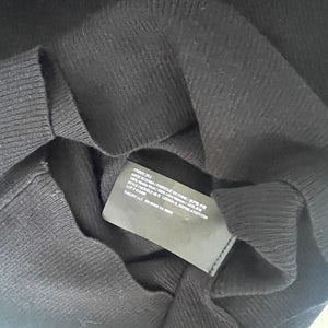 Gray sweater with a label on a dark background