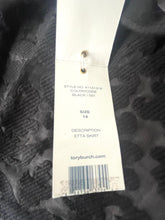Load image into Gallery viewer, A close-up of a black textured jacquard fabric with a white paper hangtag attached, showing product details including style number, color, description, size, and a barcode.
