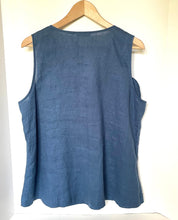 Load image into Gallery viewer, A sleeveless slate blue linen top hanging on a wooden hanger against a plain white wall.
