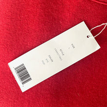 Load image into Gallery viewer, White tag with text and barcode on a red fabric background